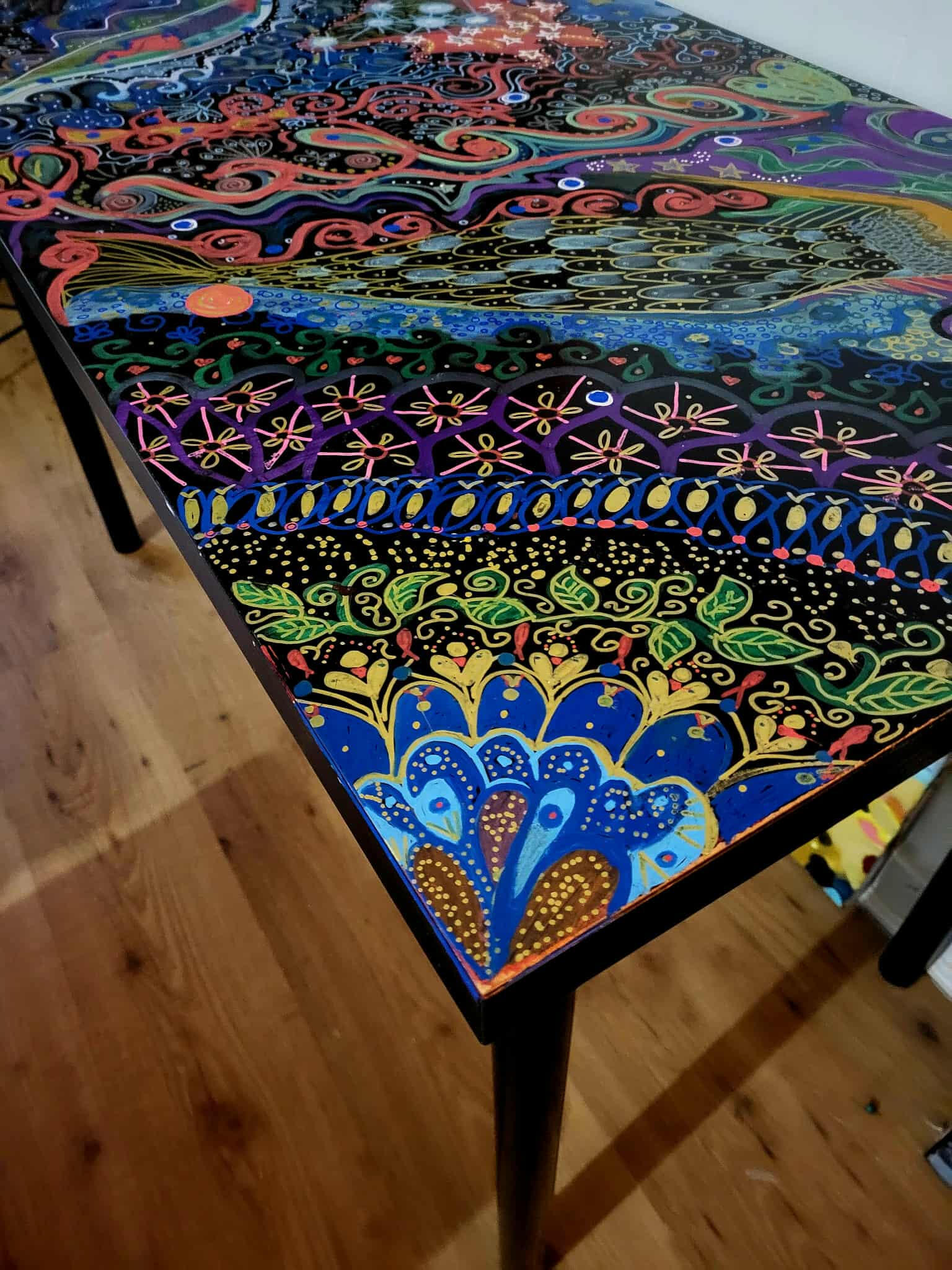 photo by Lucie Walker photof of a ceramic crow, a ceramic plate of gemstones, a lit salt lamp, a fern, some hanging ornaments in a window